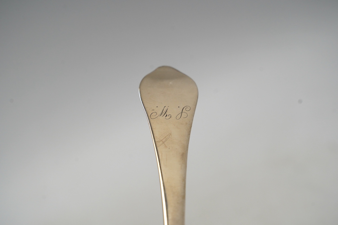 An early 18th century? silver dog nose spoon, indistinct marks, 19.2cm, together with a set of four George II silver table spoons, with lace back bowls, by William Turner, London, 1755, 10.6oz. Condition - poor to fair